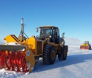 Snow blowing machinery clearning snow from the runway