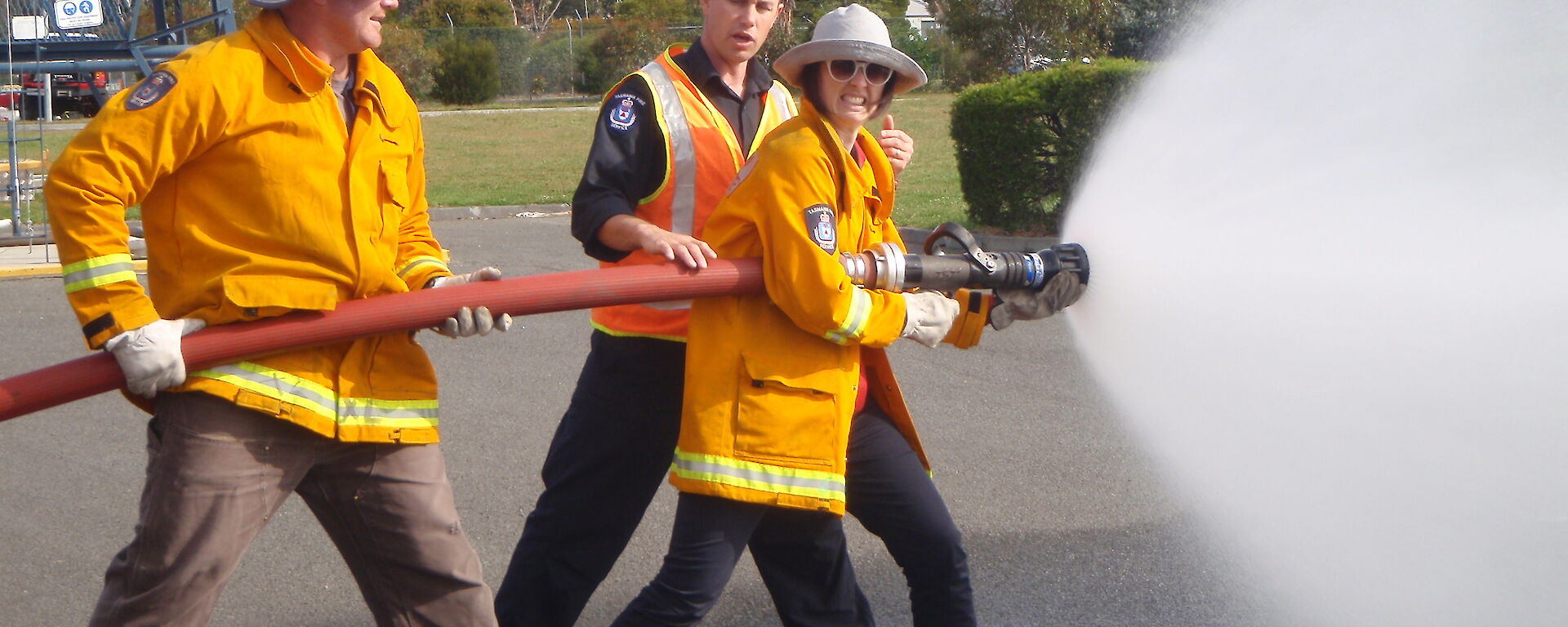 Two expeditioners being taught to use a fire hose