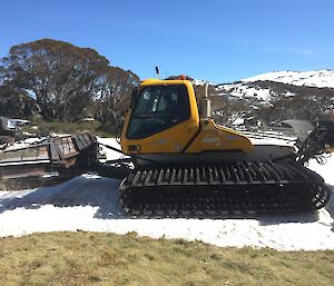 A snow groomer on a small patch of snow in the Victorian Alps