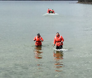 Two expeditioners wearing survival suits in the water