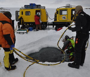 A diver entering the water via the hole in the ice.