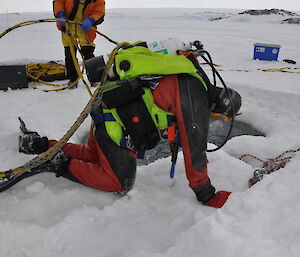 A diver falls onto the ice with the extra weight his diving suit weighs.