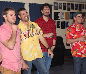 Four young men standing and watching the band play