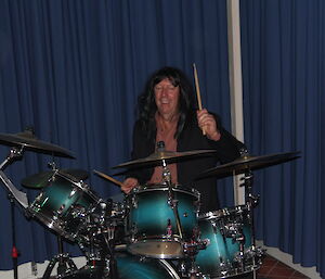 A drummer wearing a long-haired wig
