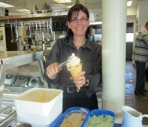 An expeditioner collects her dessert — ice cream