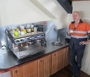 Nick reaps the benefit of his effort by having a drink from the new coffee machine