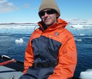 An expeditioner enjoys the sun while on the boat.