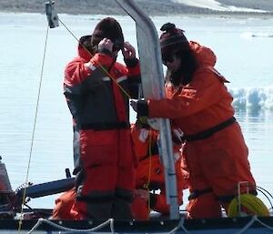 Expeditioners rigging up equipment for collecting small sea creatures.