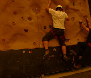 Trying out the holds on the climbing wall.