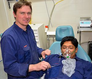 An expeditioner practises using an oxygen mask on a patient.