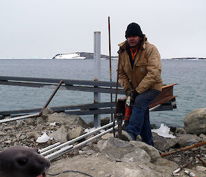 Davis wharf repairs being carried out with Cliff and Cyril drilling into rock.