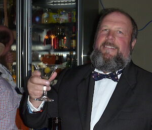 Bob Heath in a tuxedo holding a martini glass James Bond-style