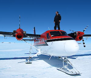 Bob Heath standing on top of an aircraft at Grove Mountains.