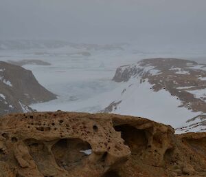 Dusting of snow of the Larsemann Hills, looking into the valley from above.