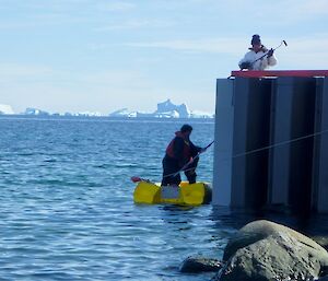 Action shot — Ken on boat and Frank on the wharf