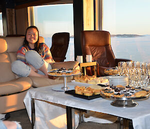 Mothers Day at Davis: Mel poses on the couch with food in foreground