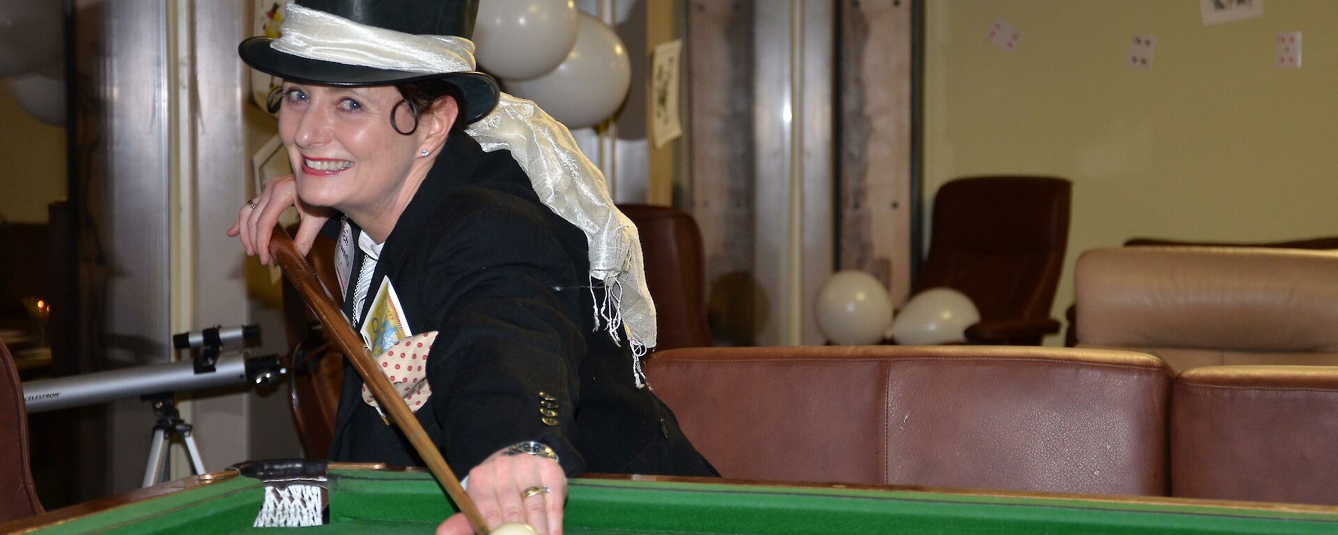 Expeditioner playing pool while wearing a top hat