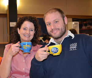 Man and woman smiling and holding colourful tea cups