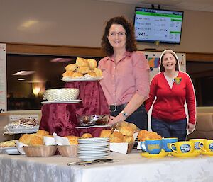 Expeditioner poses with morning tea foods while a cardboard cut out of Emily looks on