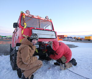 Steph MacDonald at Davis crouched in front of Hägglunds