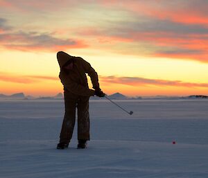 Davis Golf Game 2012 — golfer silhoutted with colourful sky laced with clouds in background