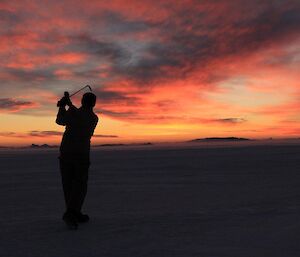 Davis Golf Game 2012 — golfer silhoutted with colourful sky laced with clouds in background