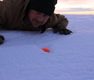 Davis Golf Game 2012. Golfer lies down on ice inspecting the position of ball