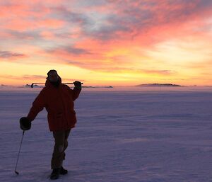 Davis Golf Game 2012. Expeditioner poses in full gear leaning on golf club with colourful sky in background