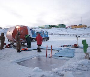 Davis Midwnter Swim 2012. A small red structure is placed next to ice pool as a changing room