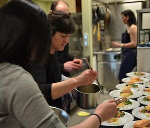 Davis midwinter dinner 2012 with people in kitchen preparing one of the courses