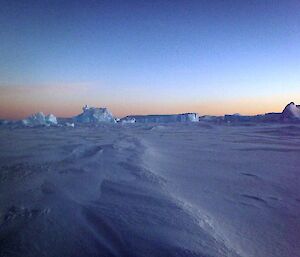 Icebergs on the sea ice with a purplish glow