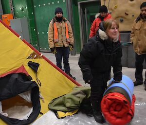 Trip preparations at Davis 2012, station leader poses in front of tent with bedroll