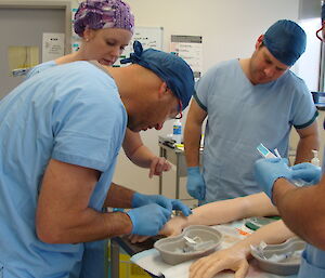 Two expeditioners practising putting a syringe into a dummy