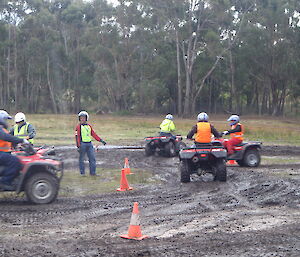 Expeditioners practising on quad bikes in muddy conditions (Tasmania)