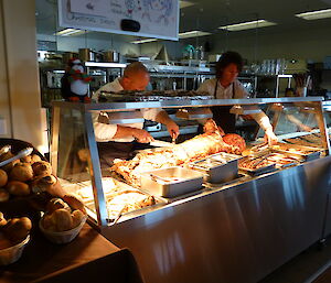 Chef carving the spit roasted lamb for christmas dinner