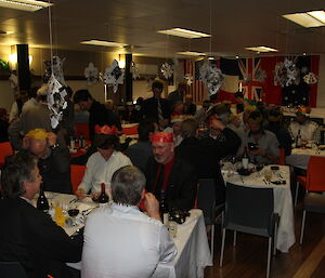 Expeditioners seated in the dining room in preparation for Christmas dinner