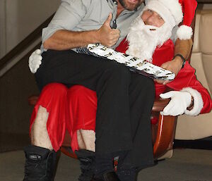 Adam sitting on Santa’s lap after receiving his present