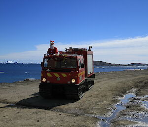 The arrival of Santa atop a red Hagglund vehicle