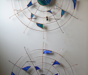 Two Davis-made clocks. metal in the shape of webs with coloured glass shards placed randomly