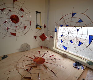 Picture of several more Davis-made clocks, metal web-like structures with glass