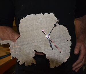 A wooden clock shaped like Antarctica