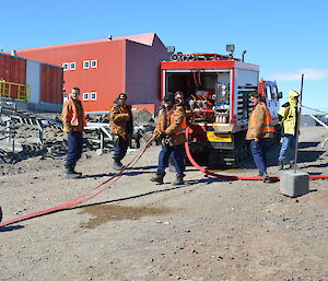 Fire team rolling out hoses on station