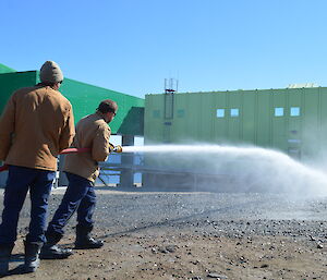 Expeditioner using a fire hose during a drill