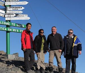 Station leaders posing under the Welcome to Davis sign