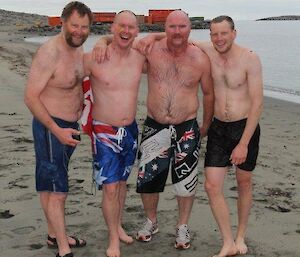 Four expeditioners posing for a photo after their Antarctic swim.