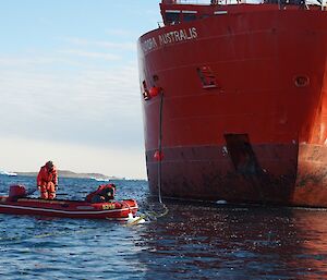 Watercraft lifting fuel hose over a block of floating ice