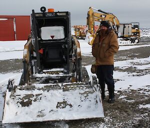 Jeff standing next to the bobcat after clearing snow