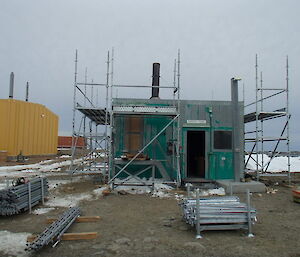 Quick stage scaffold being erected around the incinerator building in preparation for the incinerator removal