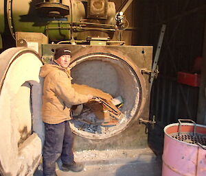 Photo of the old incinerator with a station plumber loading the material for the last burn before it is removed