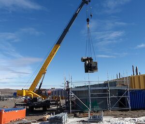 The incinerator being lifted out of the building through the roof buy the station crane